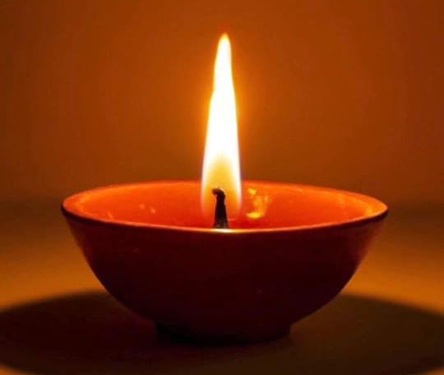 A lit diya glowing in the dark